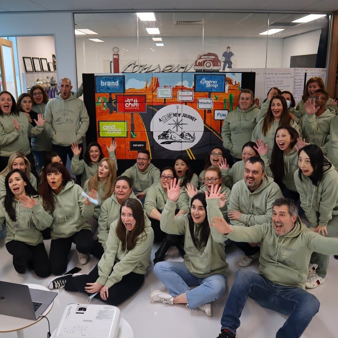 Chilli Promotions team at the Banksmeadow warehouse — designers, account managers and production team in branded sage New Journey hoodies